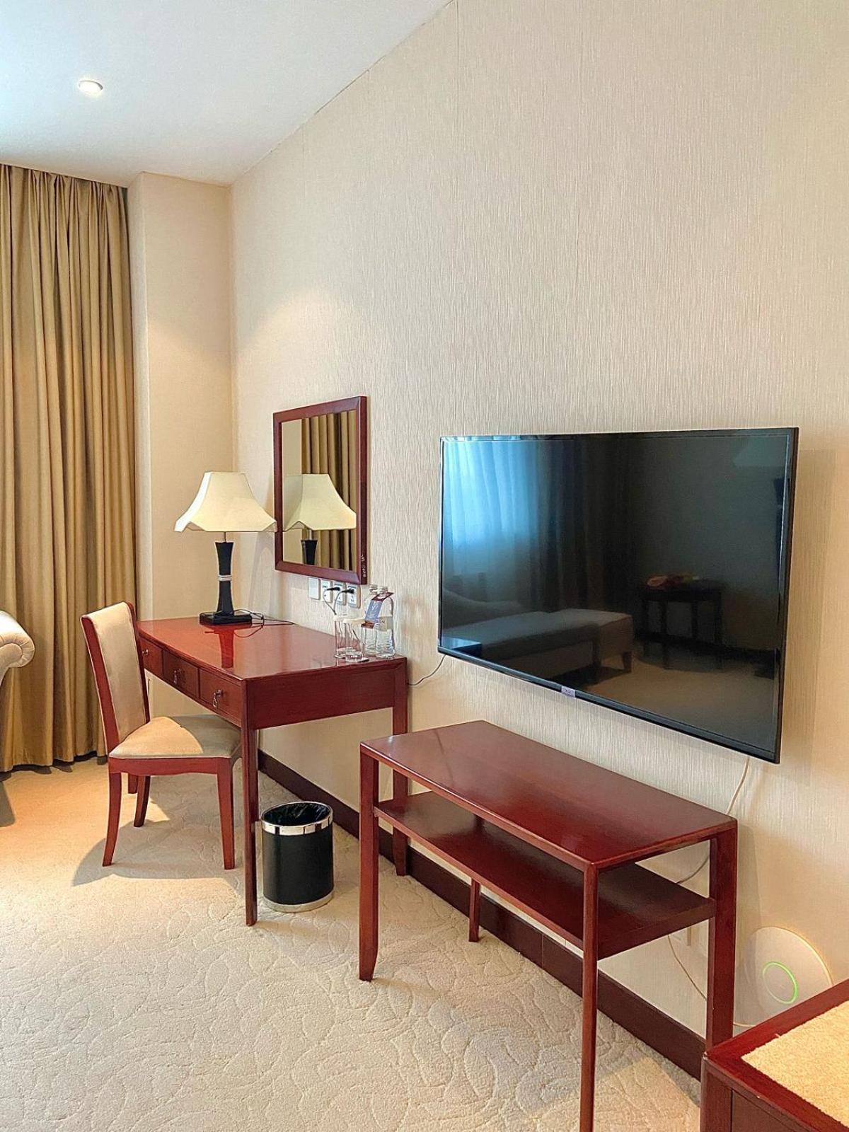 Beijing Palace Soluxe Hotel Astana Bagian luar foto A television set in a hotel room